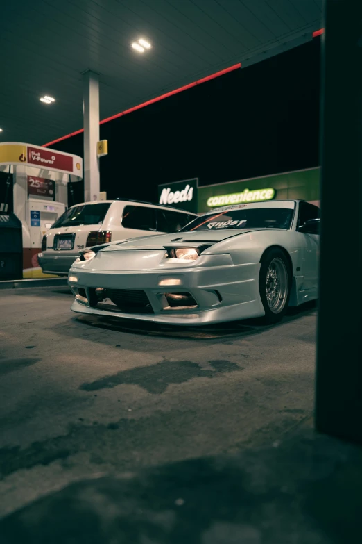 three cars parked in front of a gas station