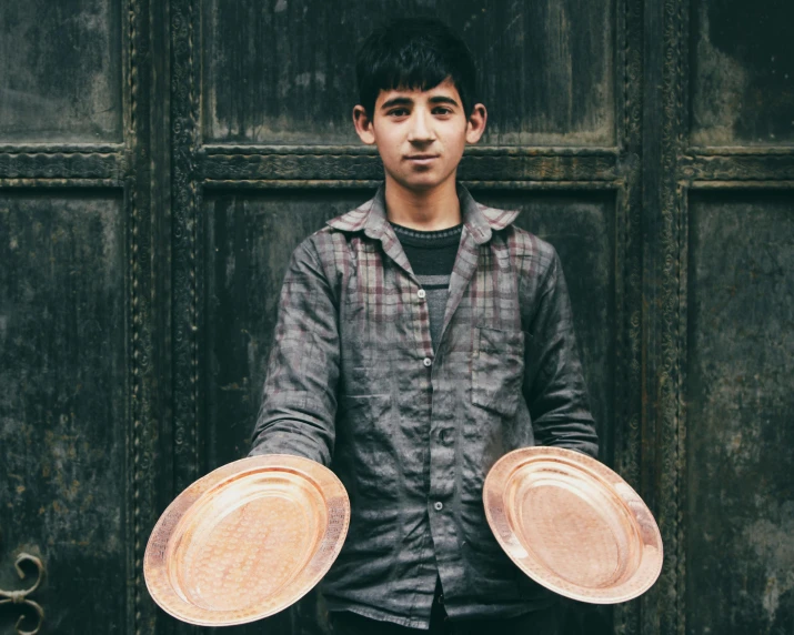 a man holding three small plates in his hands