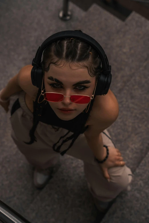 a girl with her sunglasses and headphones in front of a mirror