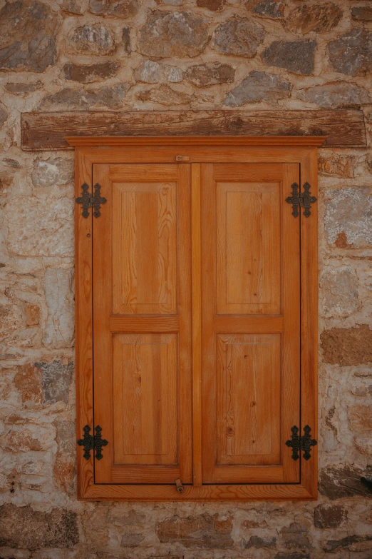 the window is made out of wood and has cross handles