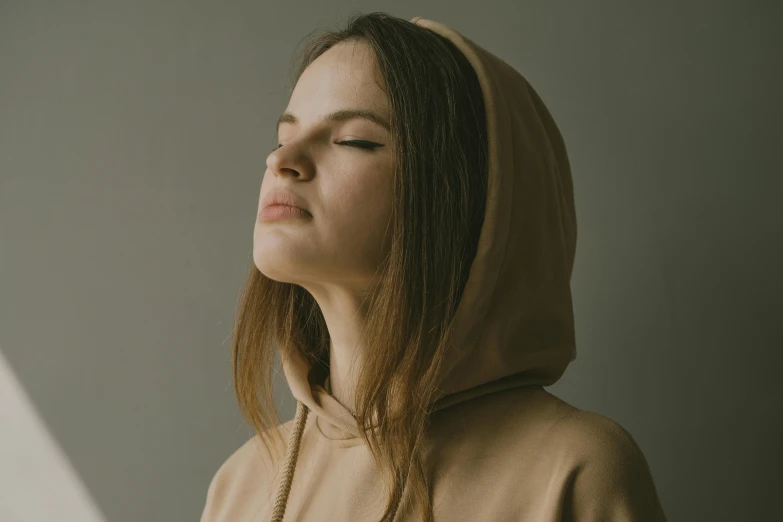 a young woman is shown from the shoulders down, with eyes closed