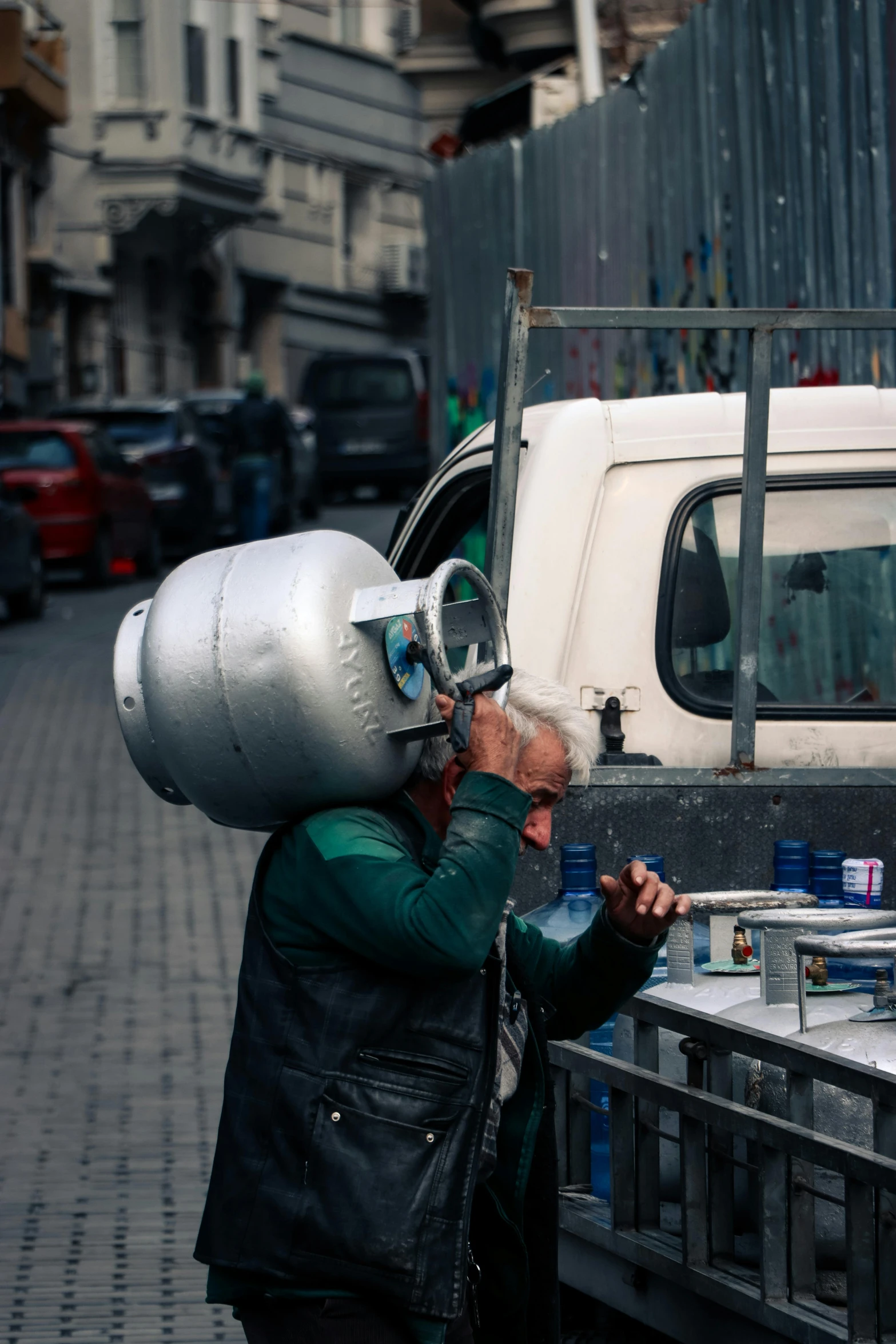 a man is carrying food on his head while he looks at his truck