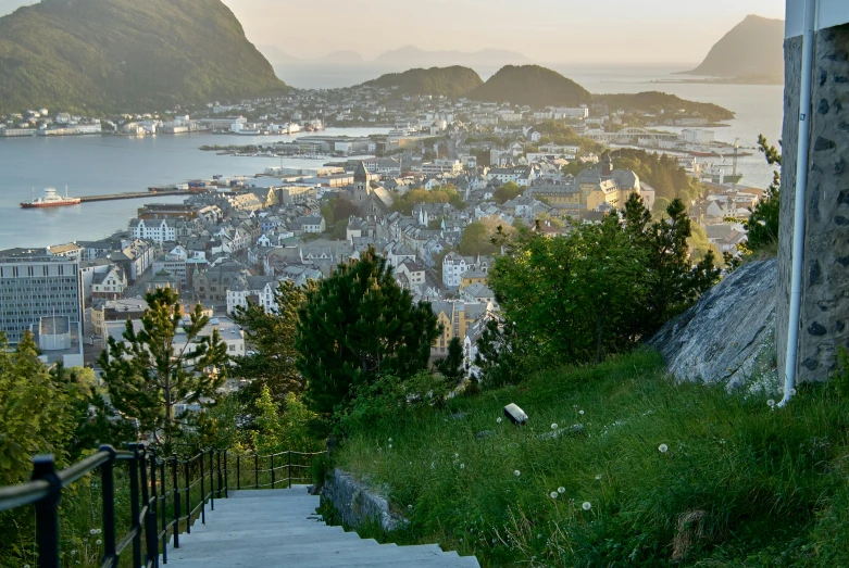 stairs lead up to the top of a hill with a city below