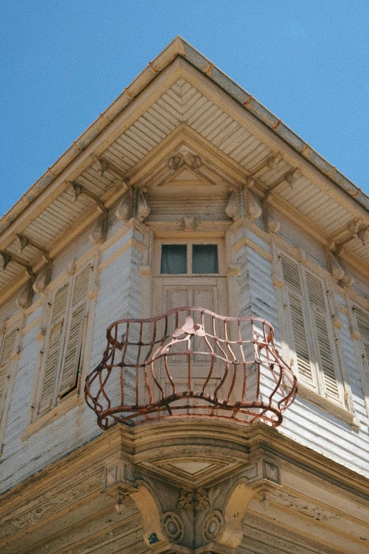 a corner of a tall building with an iron balcony