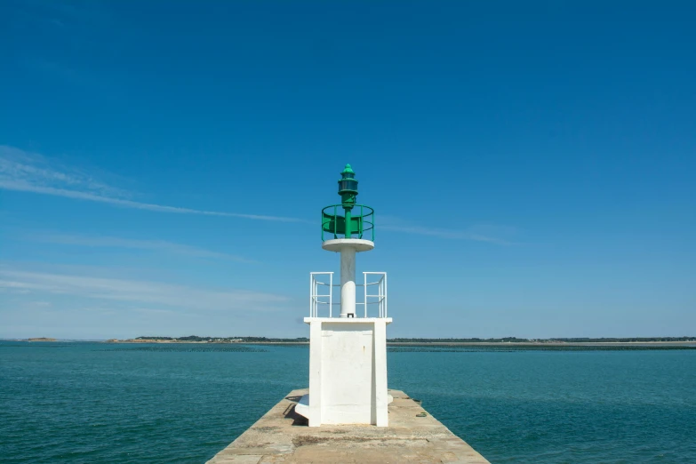 a light house at the end of a pier on a sunny day
