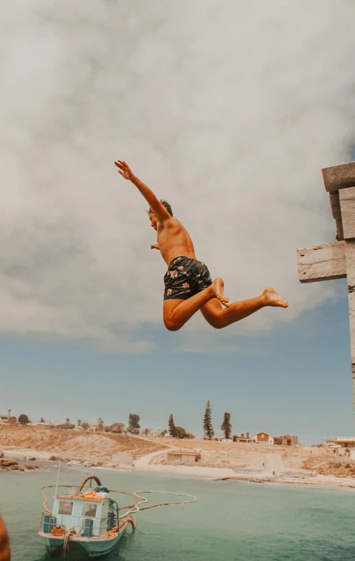 the man is jumping off the dock into the water