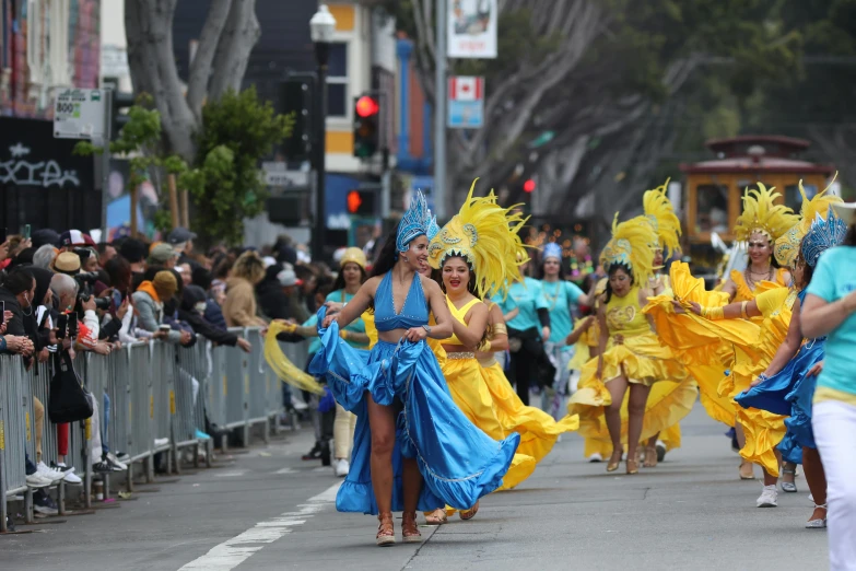 several women in costumes walk down the street