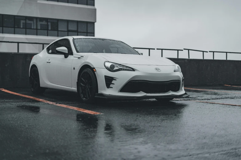 a white car parked on a wet parking lot