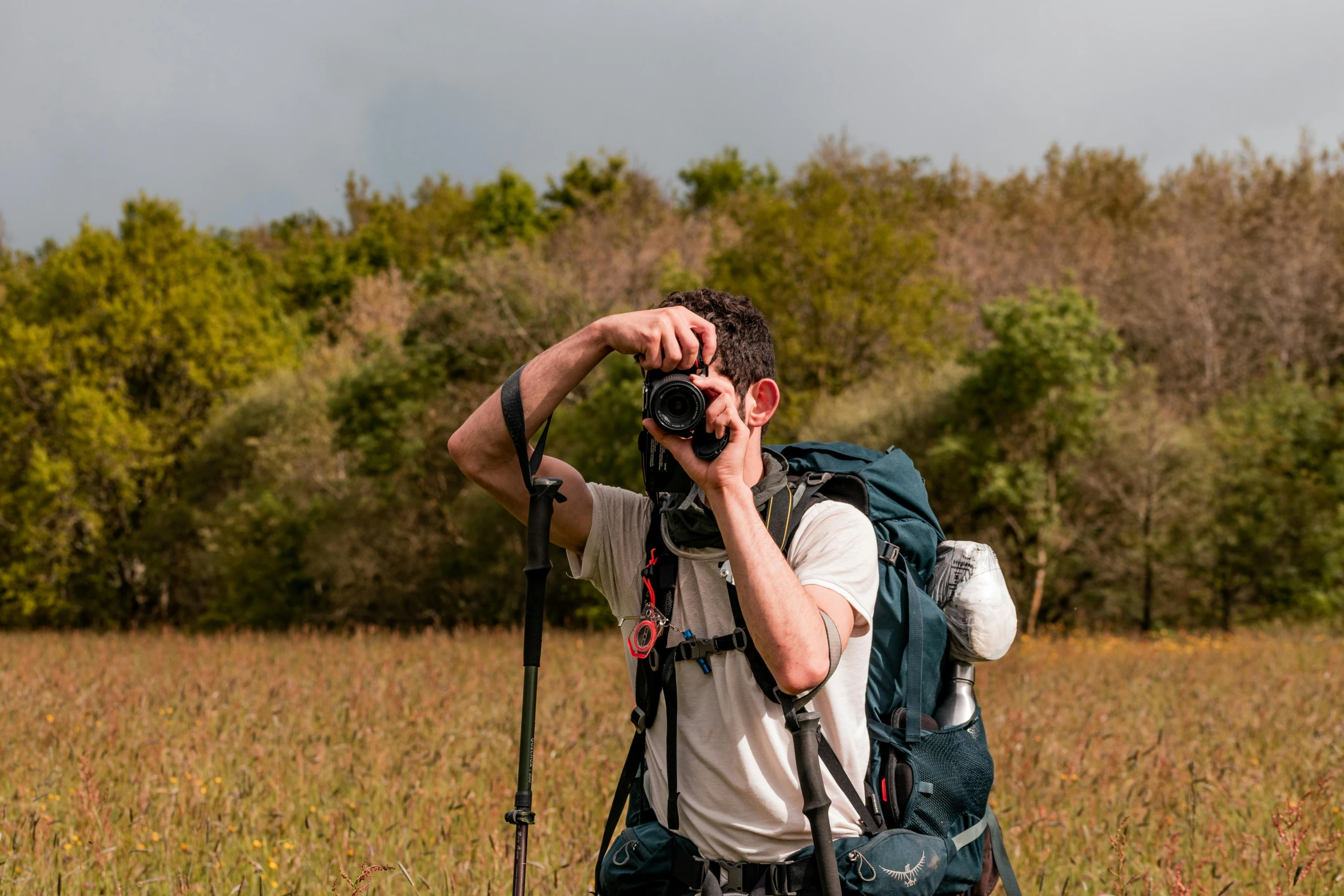 a man with a camera in the middle of a field