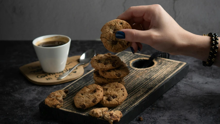 hand scooping a cookie from a plate