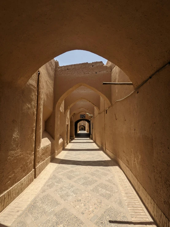 a tunnel in an alley with stone walls