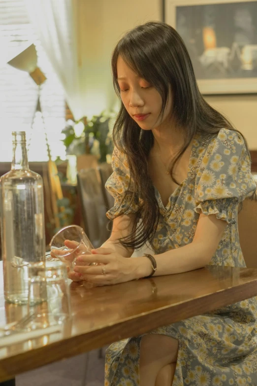 a woman sitting at a table in front of a wine glass