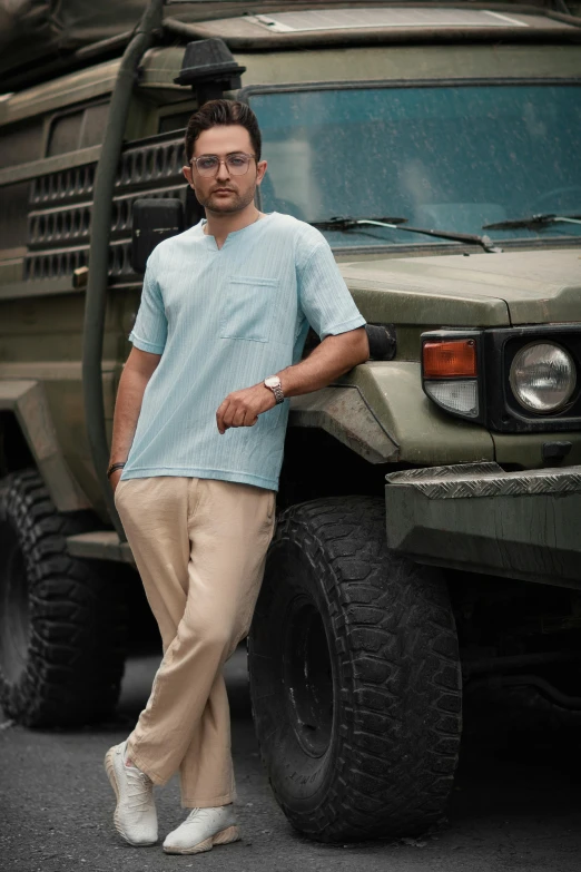 the man stands by the green truck on a street