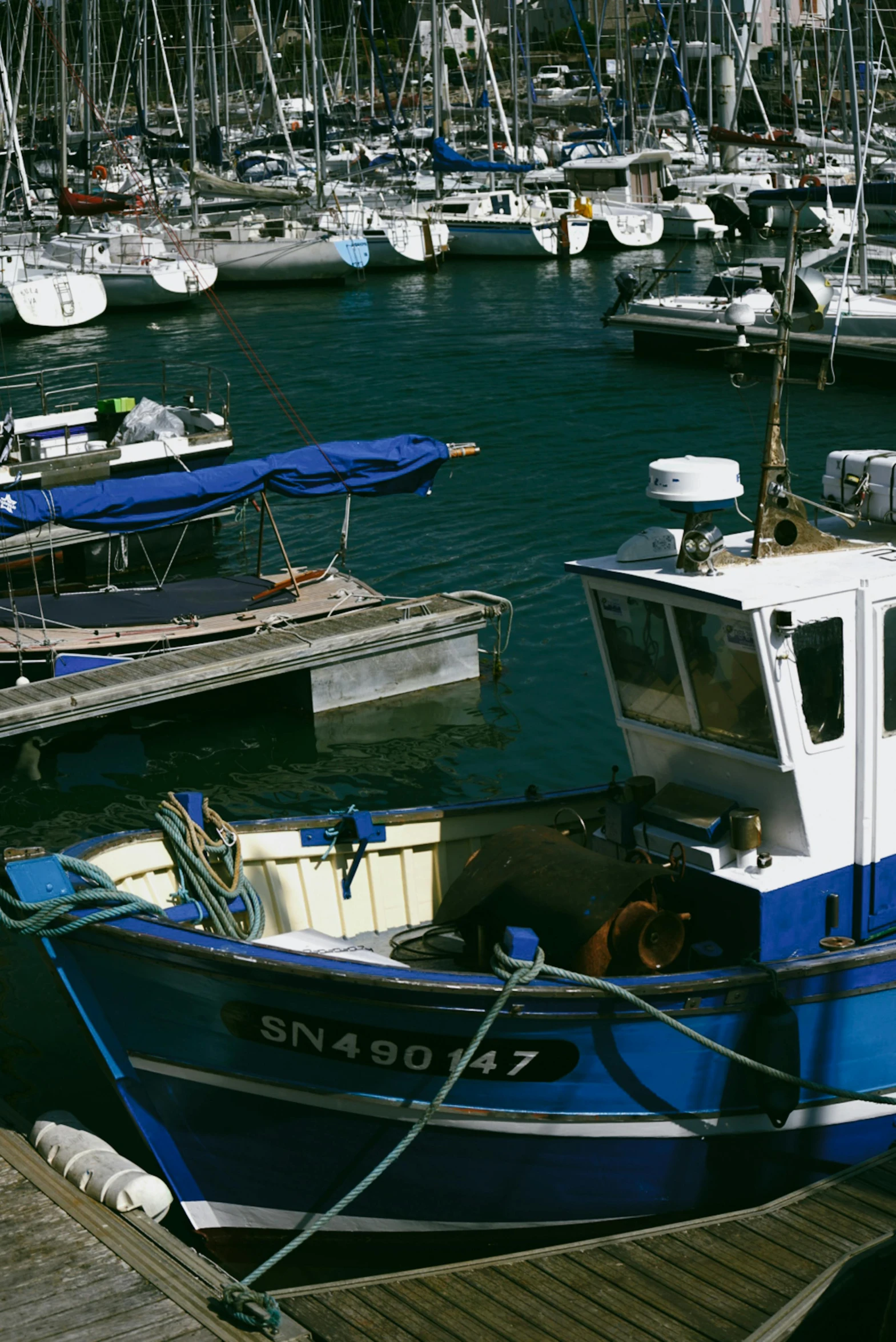 blue boat with white trim parked at the dock