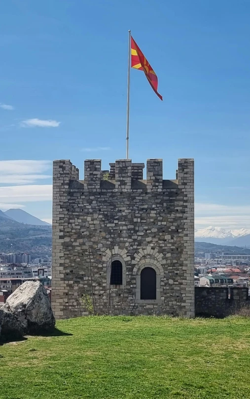 an old brick building with two flags in front of it