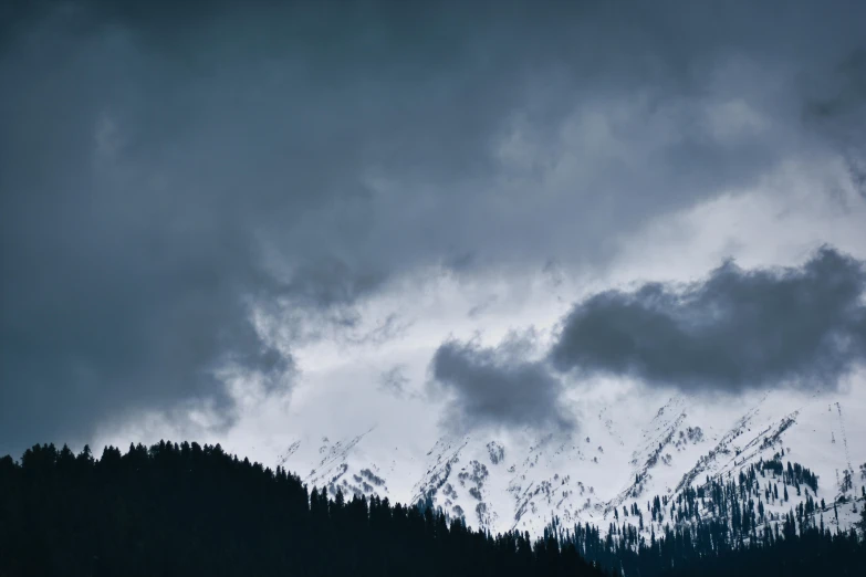 several mountains covered in snow and clouds during the night