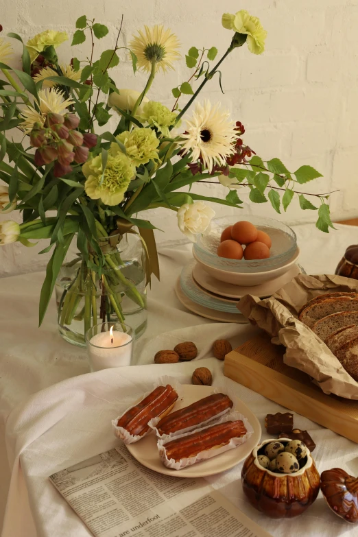 a vase filled with white flowers next to plates of food