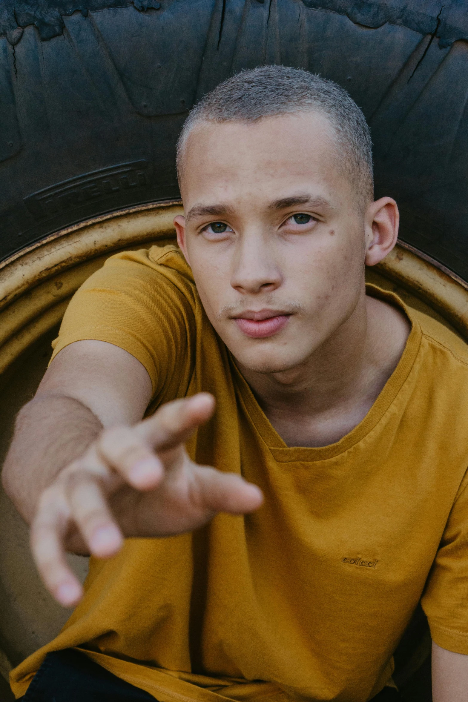 a man in yellow shirt pointing to soing on top of a shelf