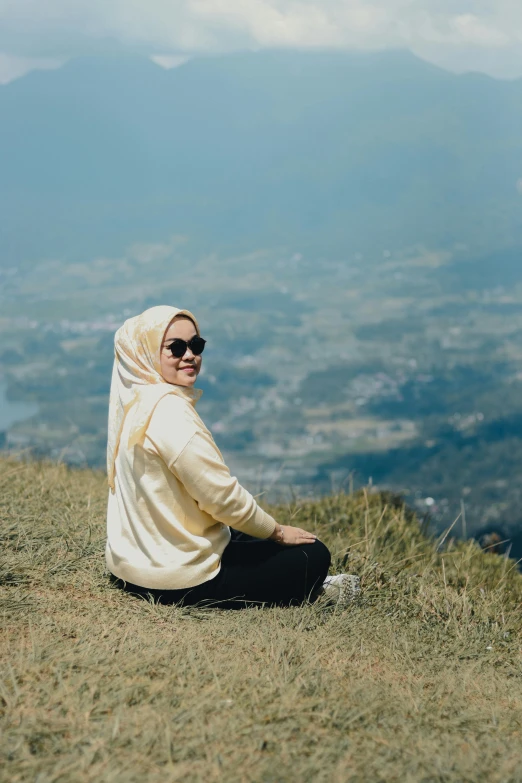 a woman wearing glasses on top of a hill