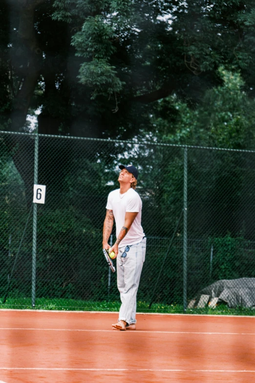 a tennis player is looking up at the sky