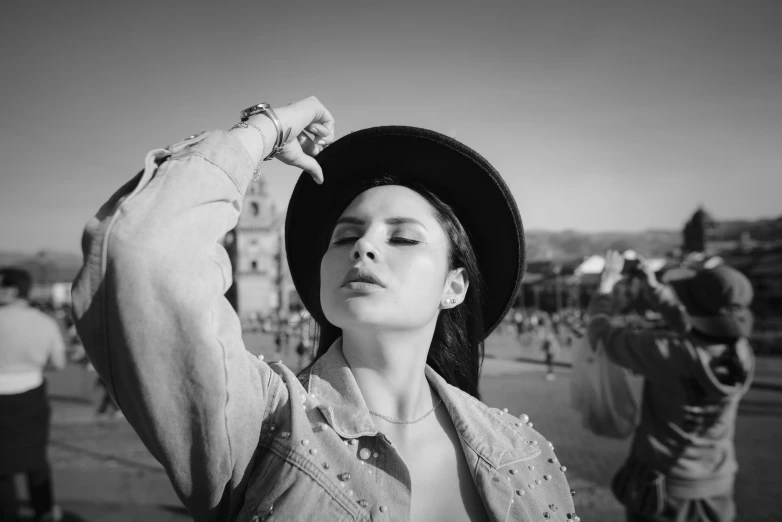 a woman wearing a hat in the middle of a crowd