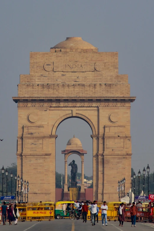 people are standing on a paved street by an archway