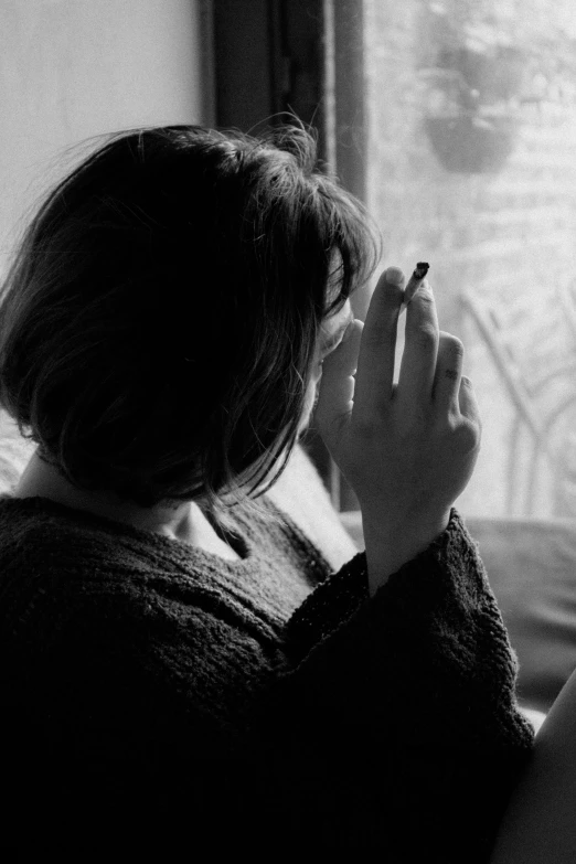 the back view of a person sitting on a couch looking out a window