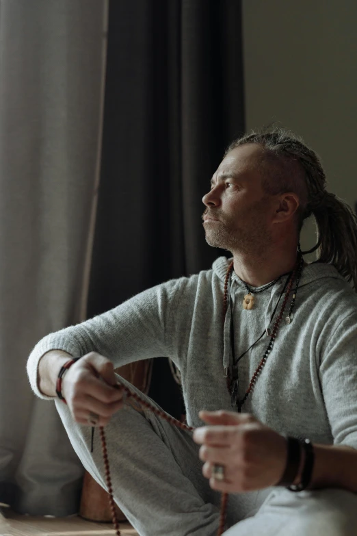 a man with ear rings sitting down