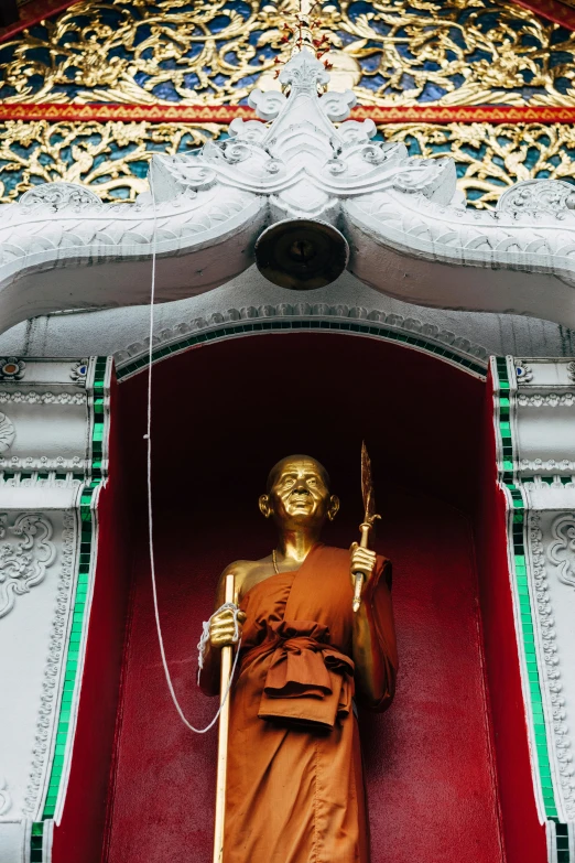 a statue holding a golden object on top of a building