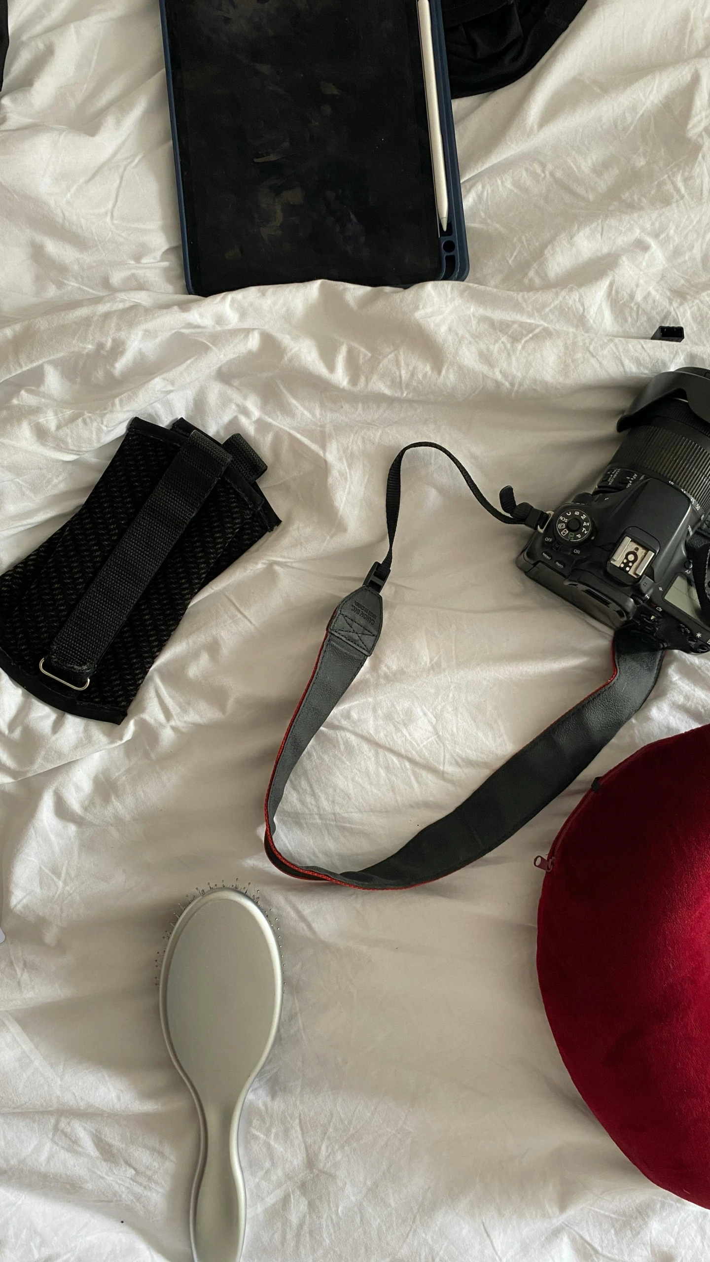 a red hat a phone and other items on top of the bed