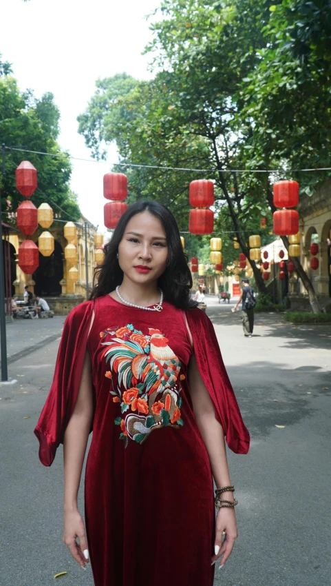 a young woman in an asian fashion poses near lanterns