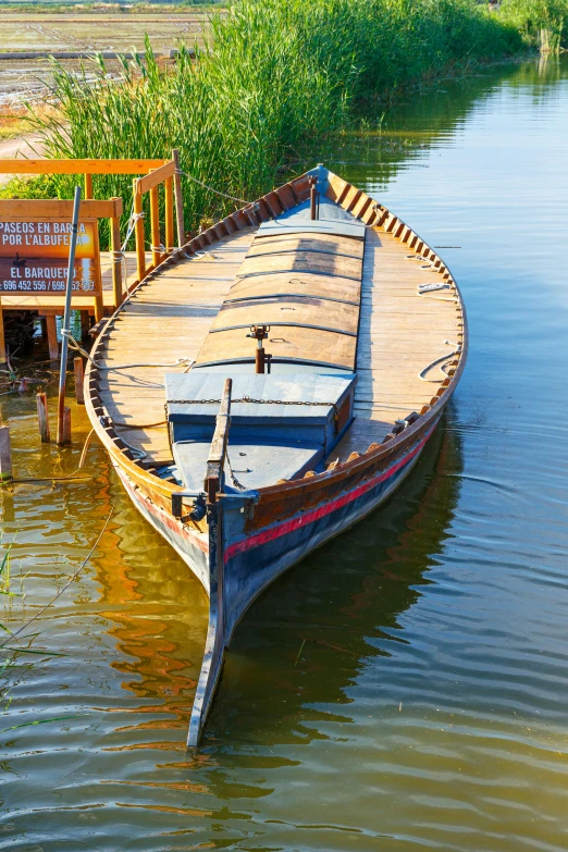 a boat sits in the water beside some benches