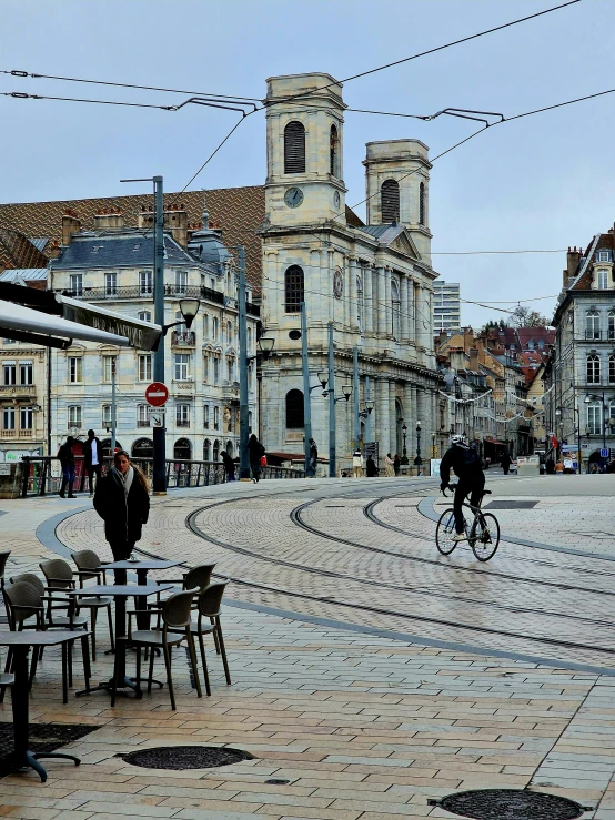 a man rides his bicycle through an urban square