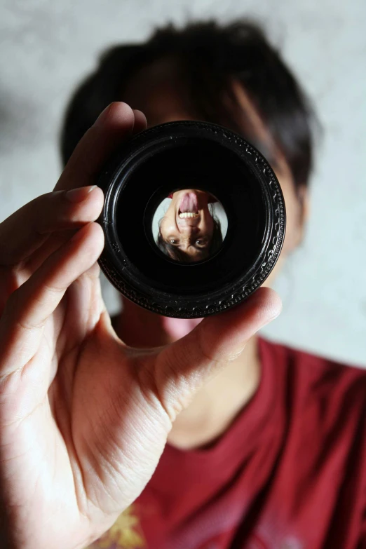 a man takes a po through a small lens