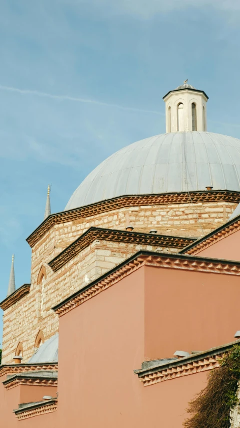 an old building with an unusual dome sits at the edge of a city