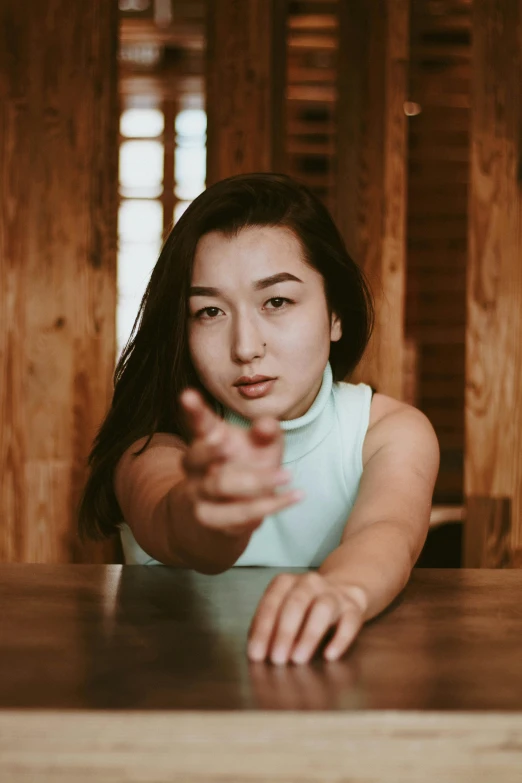 a person sits at a table with her finger out