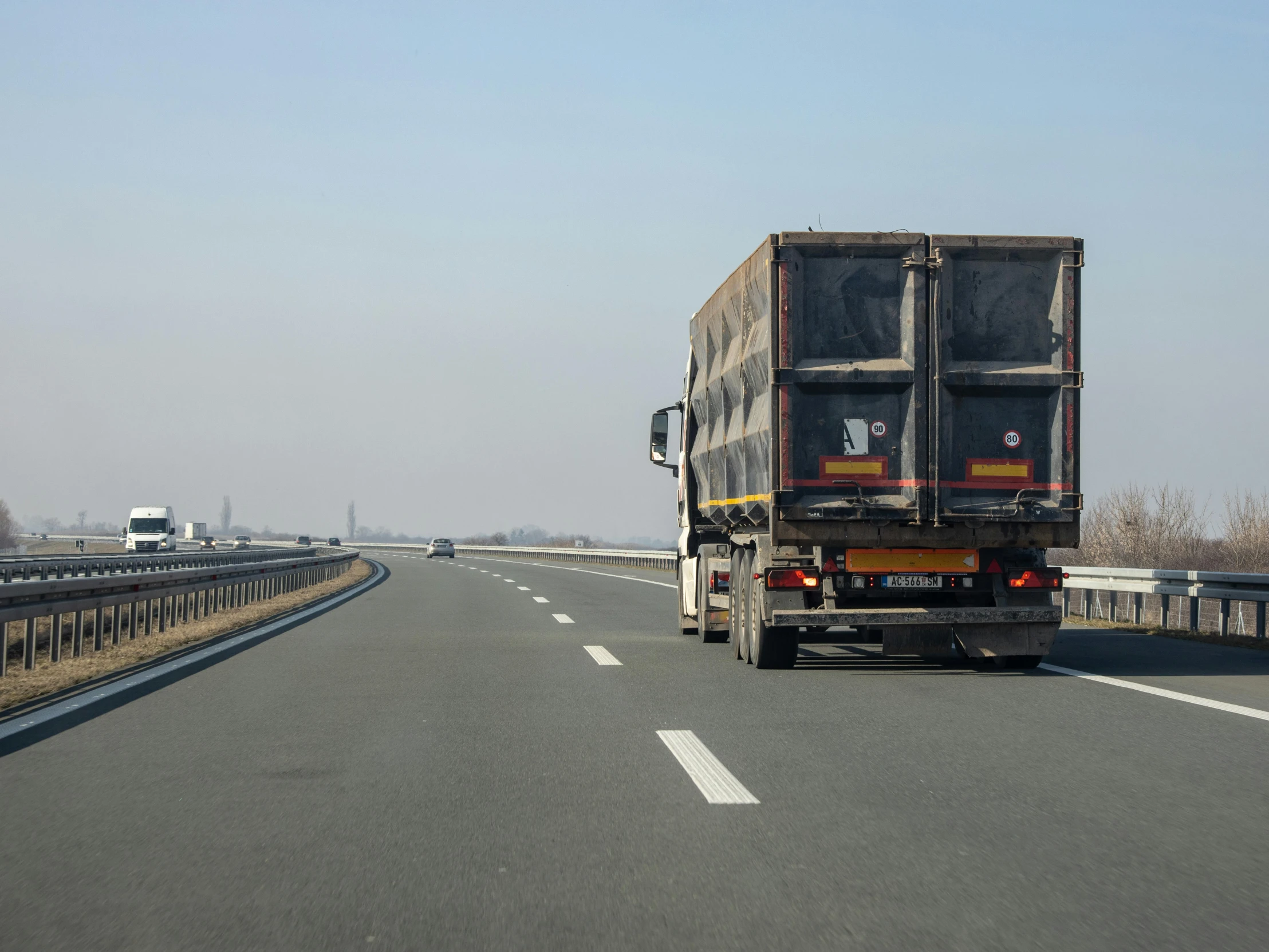 a truck driving down the road with lots of cargo