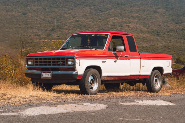 a red and white truck parked in the grass