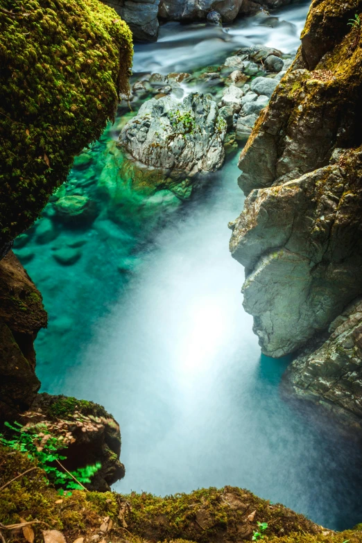 a blue - green river runs through some rocks