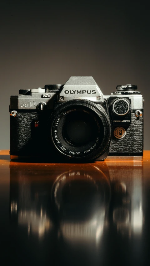 an old camera on a table with a dark back ground