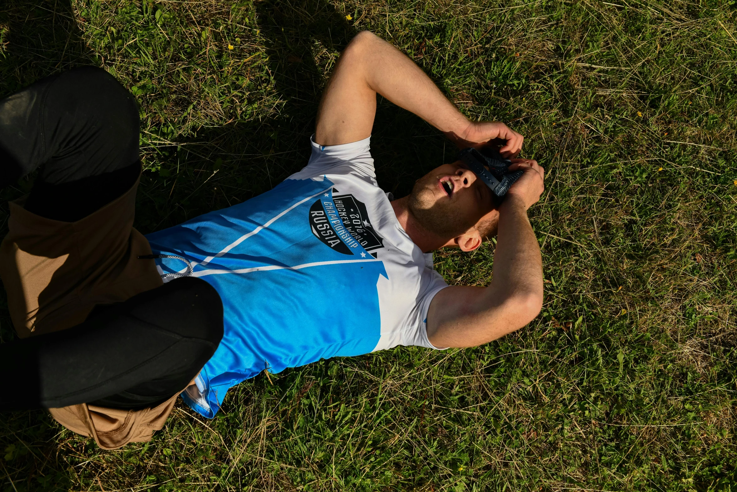 a man laying down in the grass with his skateboard