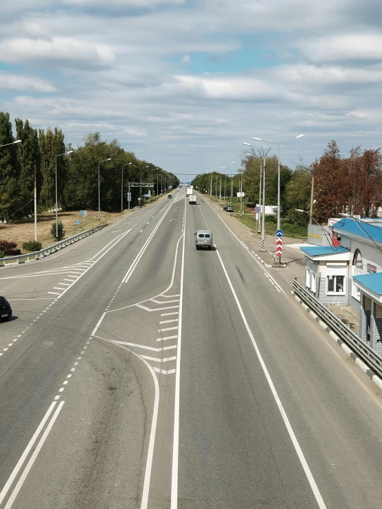 a long empty city street with a van driving