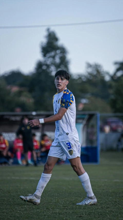 a young man in soccer uniform on the field playing soccer