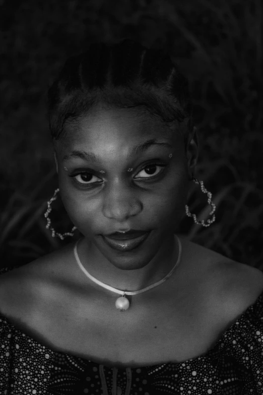 a woman with large earrings posing for a black and white po