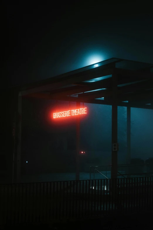 a red sign hanging from the side of a building at night