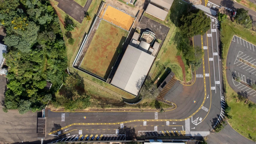 an aerial view of a parking lot on an overhead view of a street and trees