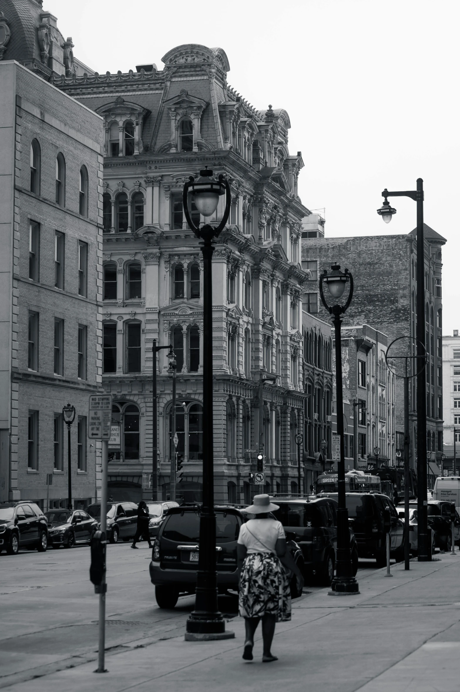 a woman walking on the street next to a clock tower