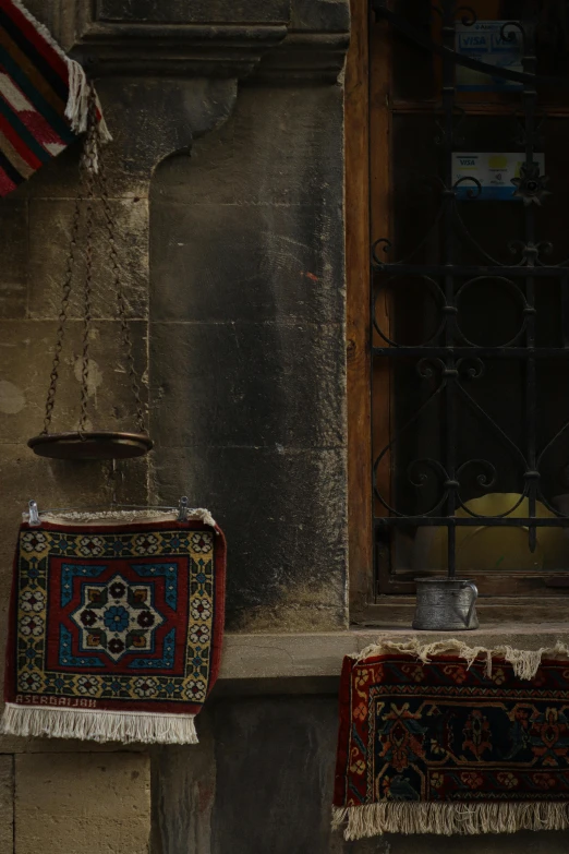 two rugs sit outside an old building on the sidewalk