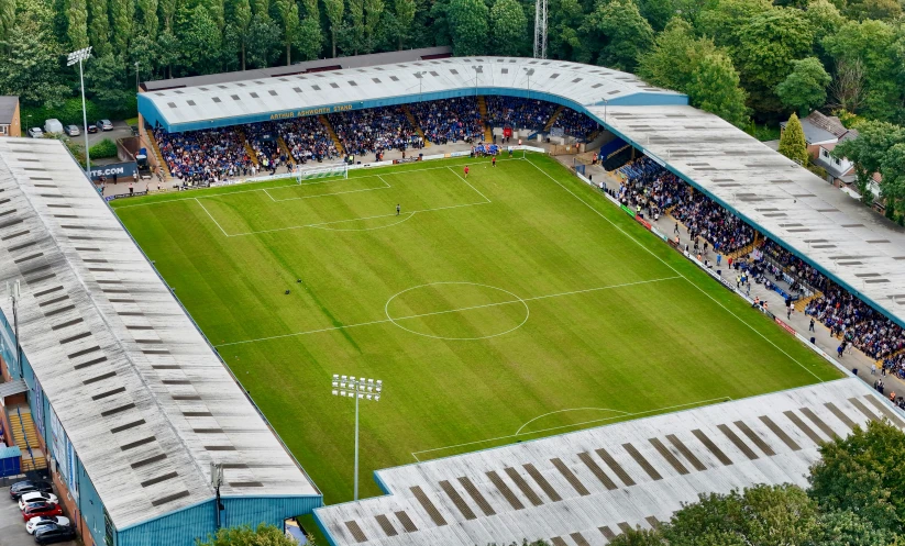 the stadium is full of people and has a green field