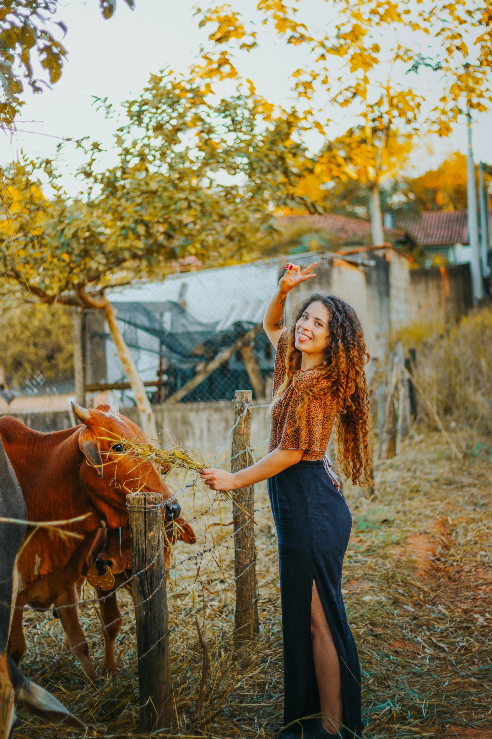 a woman standing in front of a horse by a fence